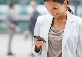 A woman looking down at cell phone smiling