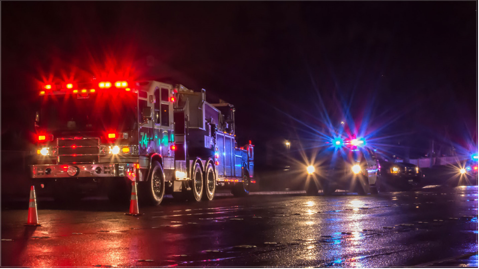 Fire truck and police car parked beside each other with siren lights on