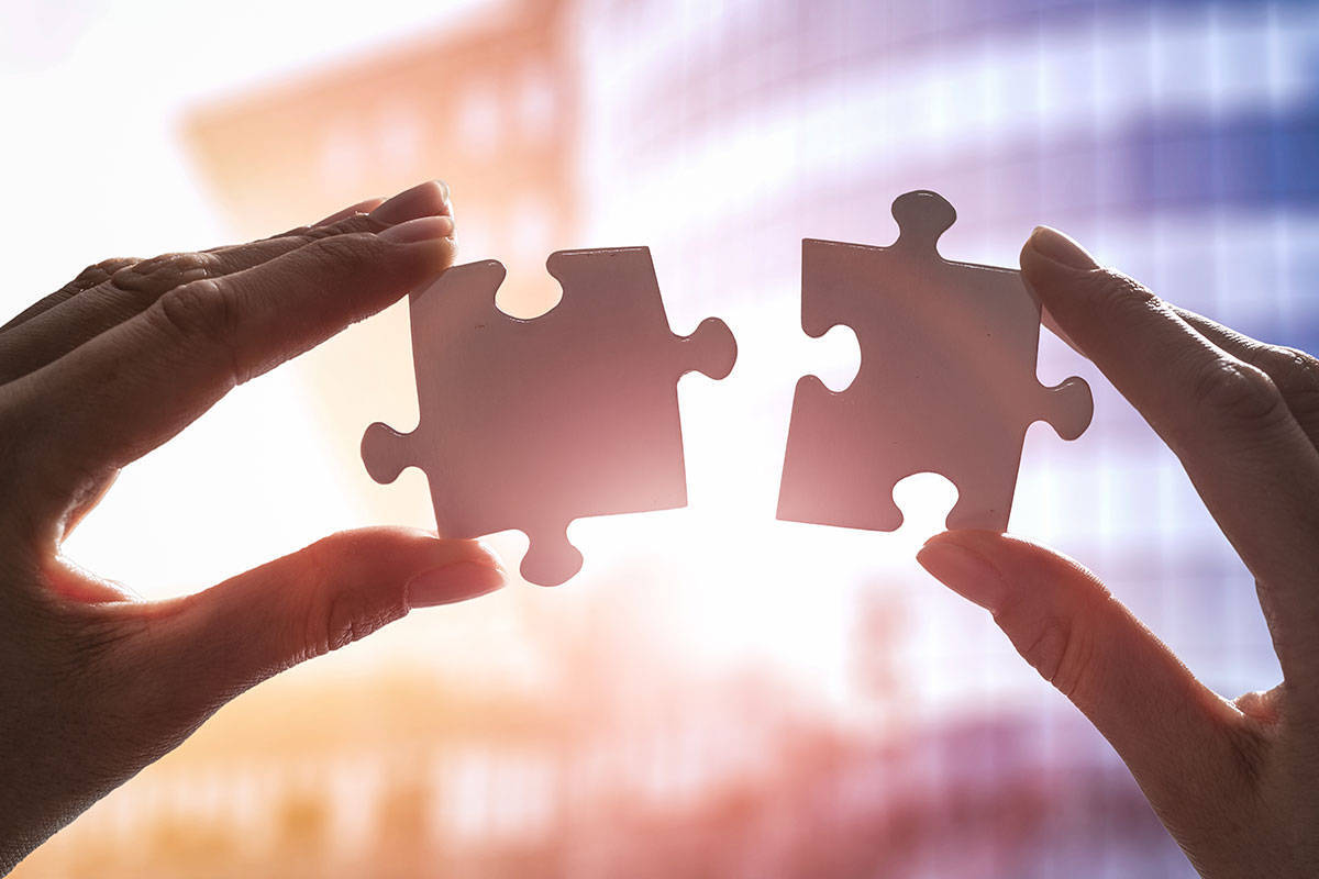 A person holding up two puzzle pieces